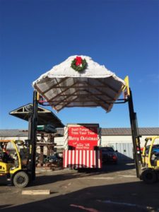 forklift lifting roof onto santa clause parade float