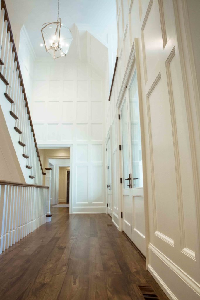 wainscoting through hallway from floor up to vaulted ceiling